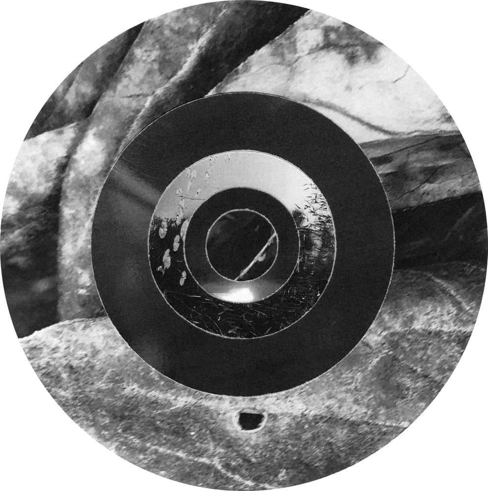 Circular black-and-white collage of rough bark and veined leaf fragments arranged in concentric rings.