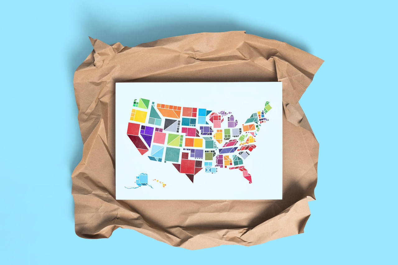 Tangram States United States map print displayed on crumpled brown packing paper against cyan.