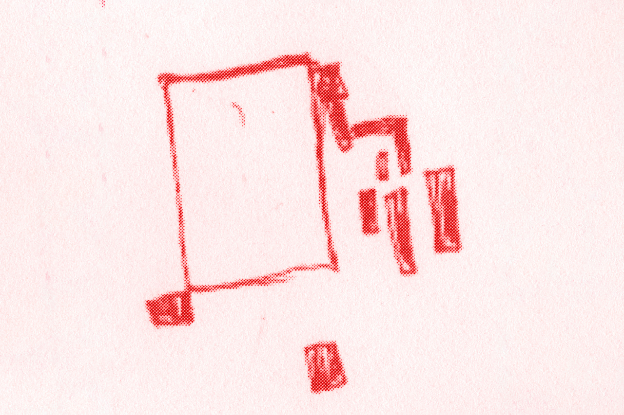 Red pencil outline with small detached geometric pieces on pale paper.
