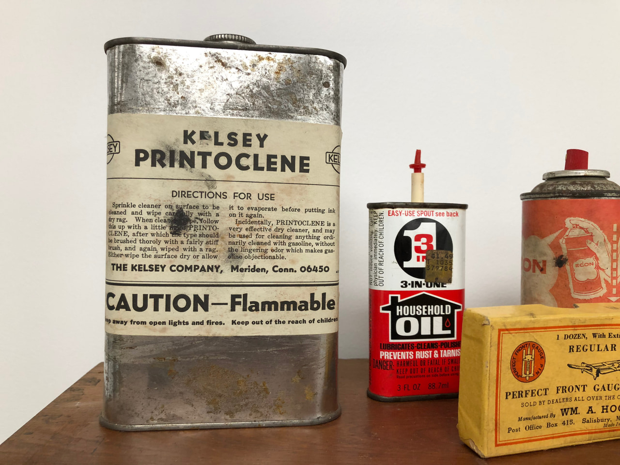 Close-up of vintage printing-solvent and oil containers on a museum display shelf.