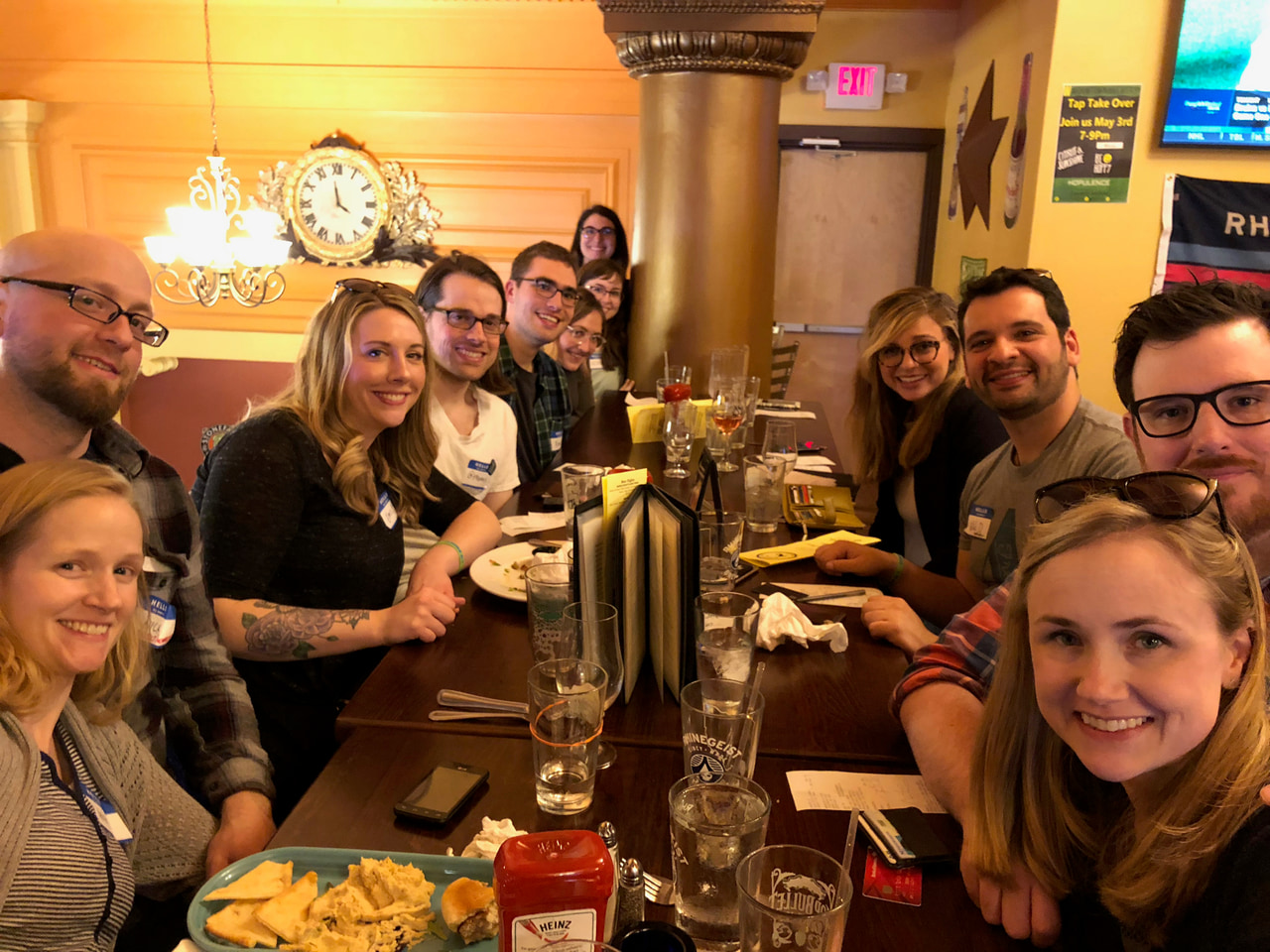 Group gathered around a restaurant table with food and drinks.
