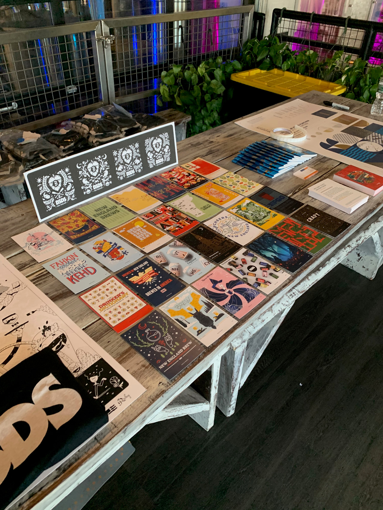 Table displaying colorful posters, publications and a large black-and-white BSDS print.