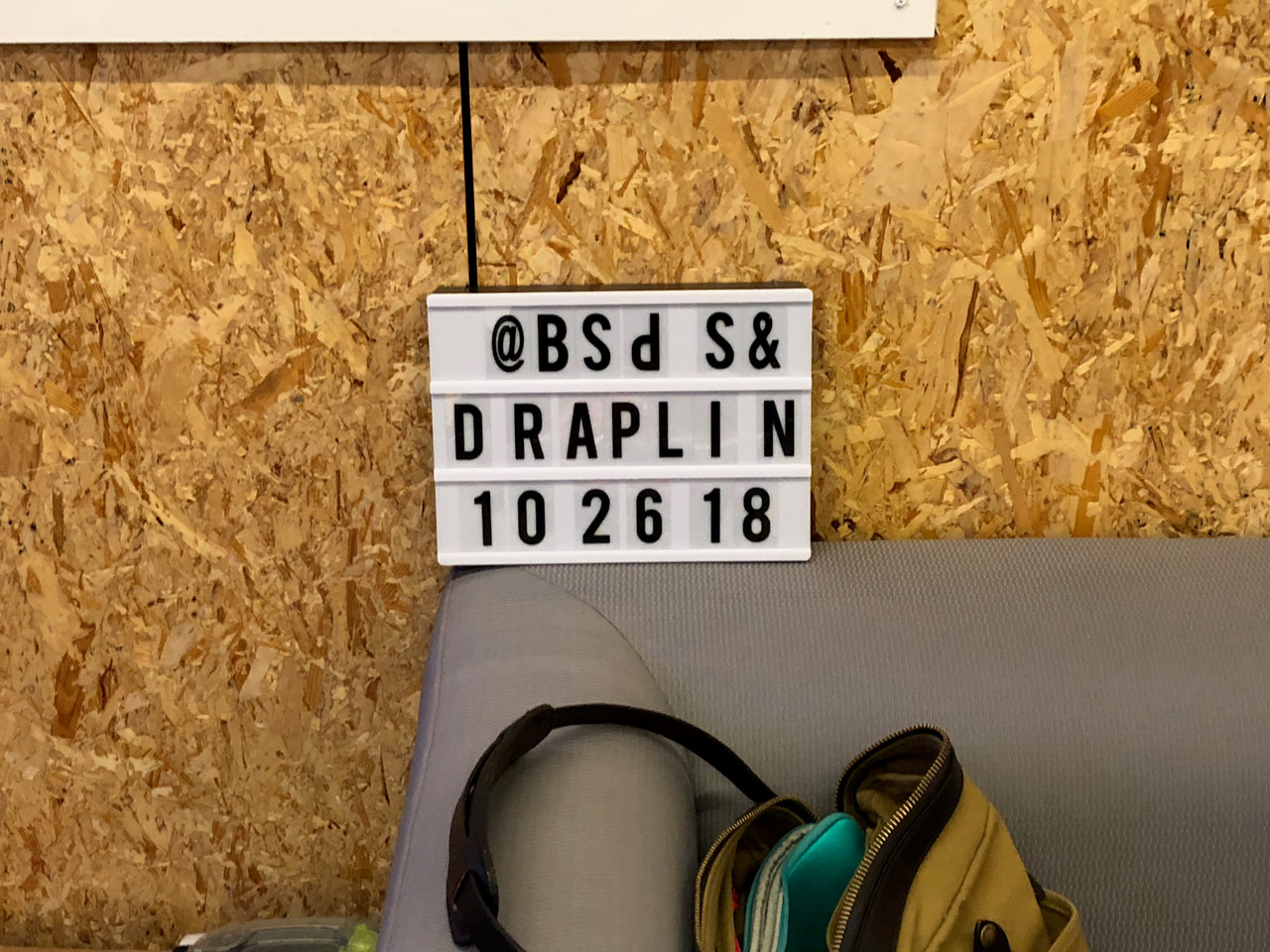 Small letterboard reading @BSDS & Draplin, 102618, mounted on a wood-panel wall.