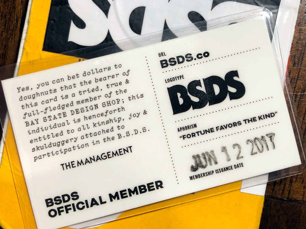 Overlapping BSDS membership cards with black typography on cream paper.