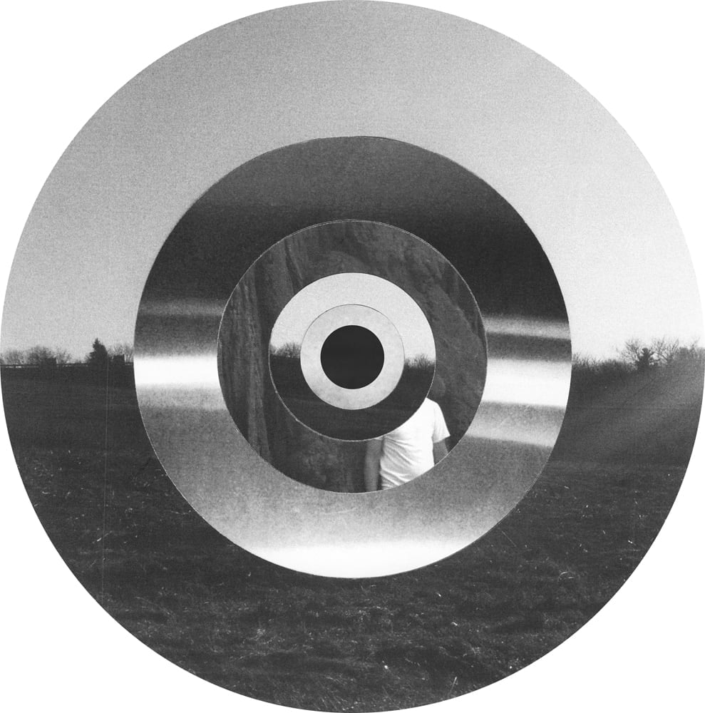 Concentric photographic rings combining a pale sky, dark landscape horizon and blurred highlights in black and white.
