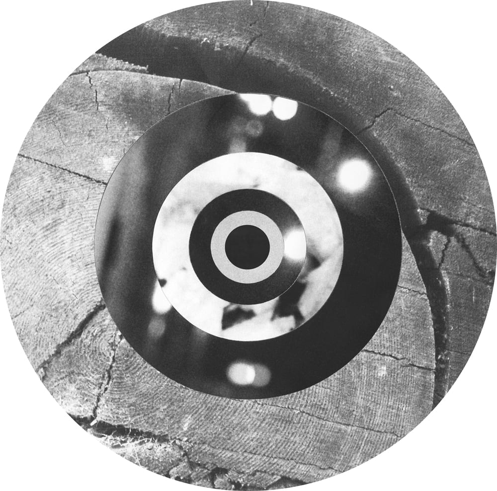 Circular black-and-white collage combining wood grain, blurred light spots and concentric rings.