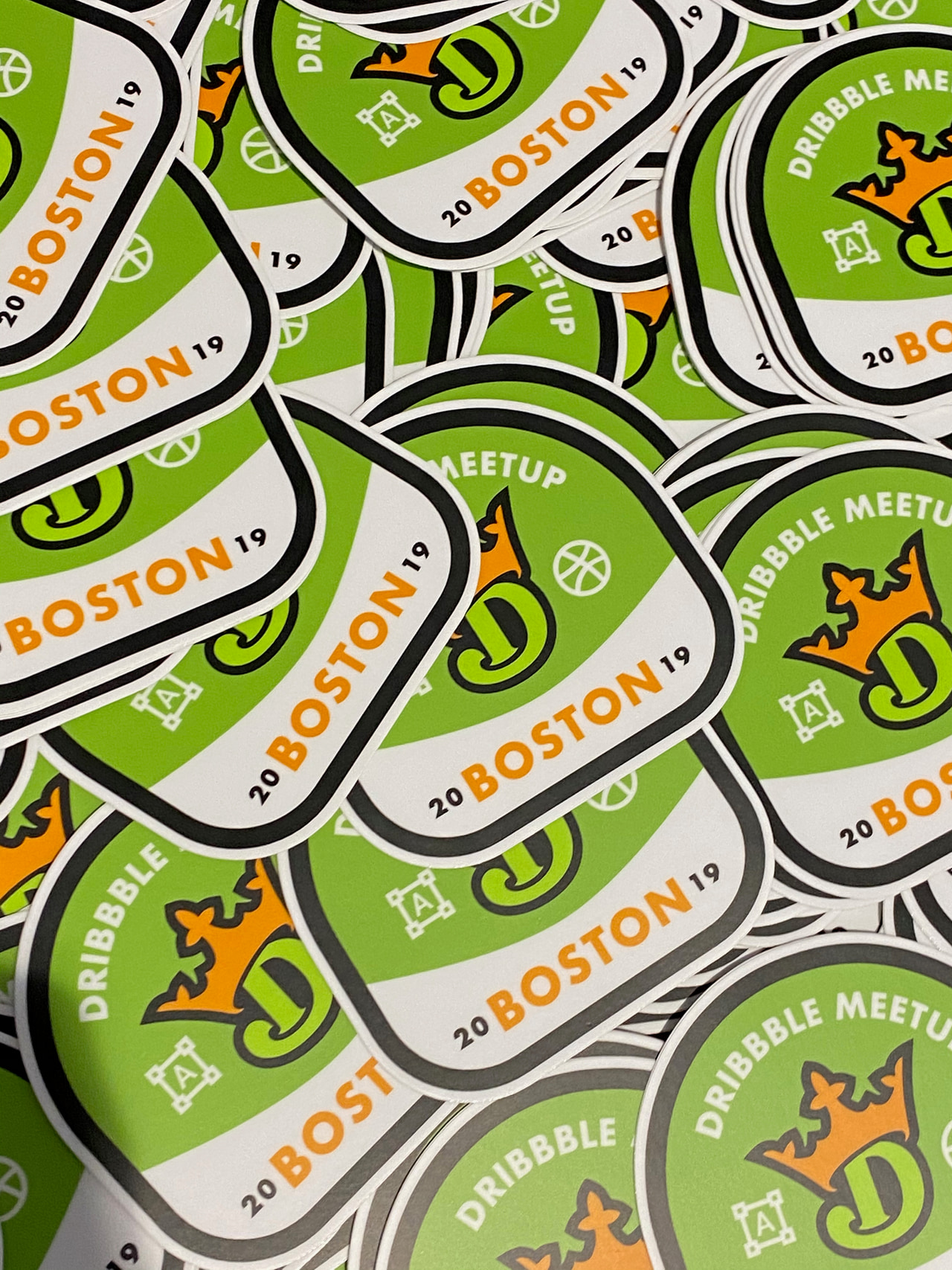 Overlapping green-and-cream Boston Dribbble Meetup stickers with basketball and ornamental figures.
