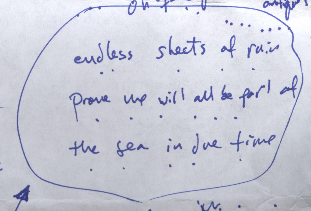 Circled blue handwritten poem draft: Endless sheets of rain prove we will all be part of the sea in due time.